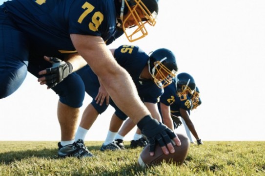 Young team of pro footballers offensive line at practice